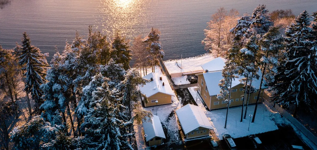 Vista aérea da sauna e do local de nado no gelo à beira do lago no inverno, Joensuu