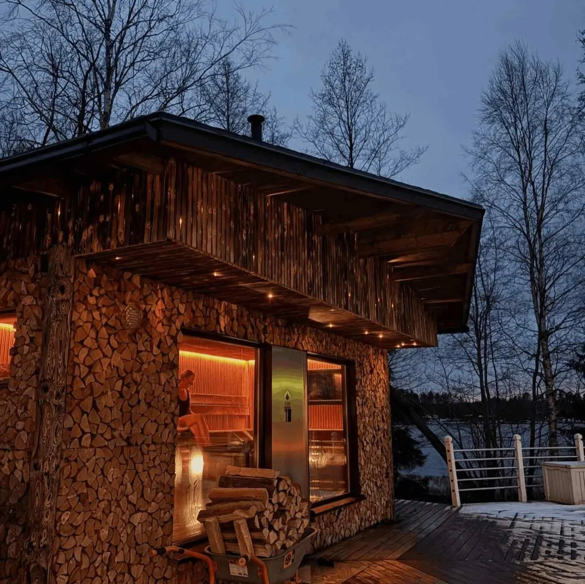 Sauna revestida de lenha empilhada ao entardecer de inverno, Rauma