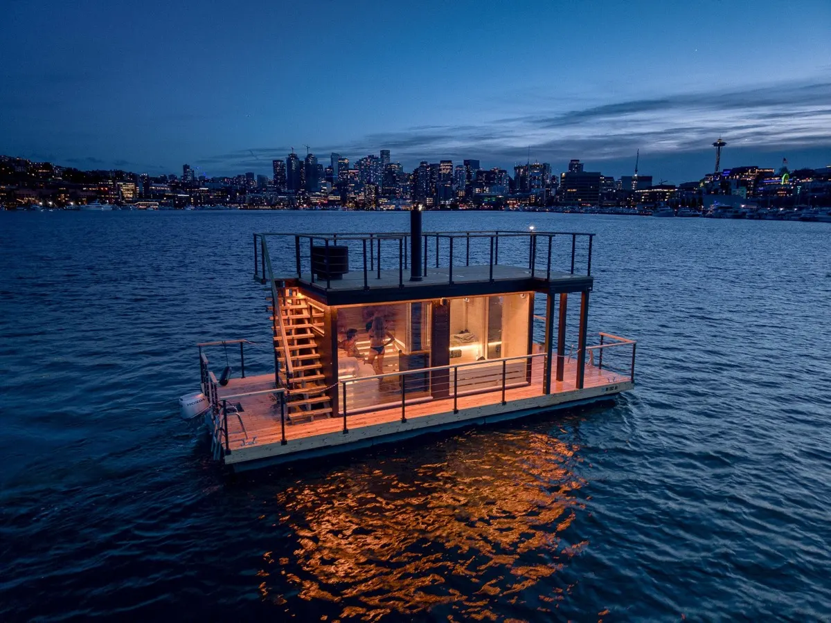 Barco-sauna da Wild Haus no Lake Union ao anoitecer, com o centro de Seattle ao fundo